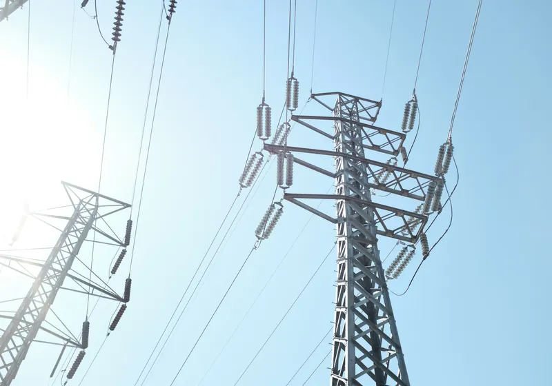 Electricity pylons and power lines against a blue sky